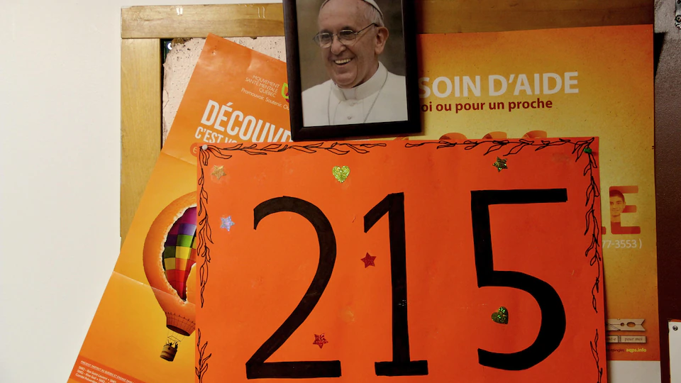 A photo of Pope Francis and a poster showing the number 
