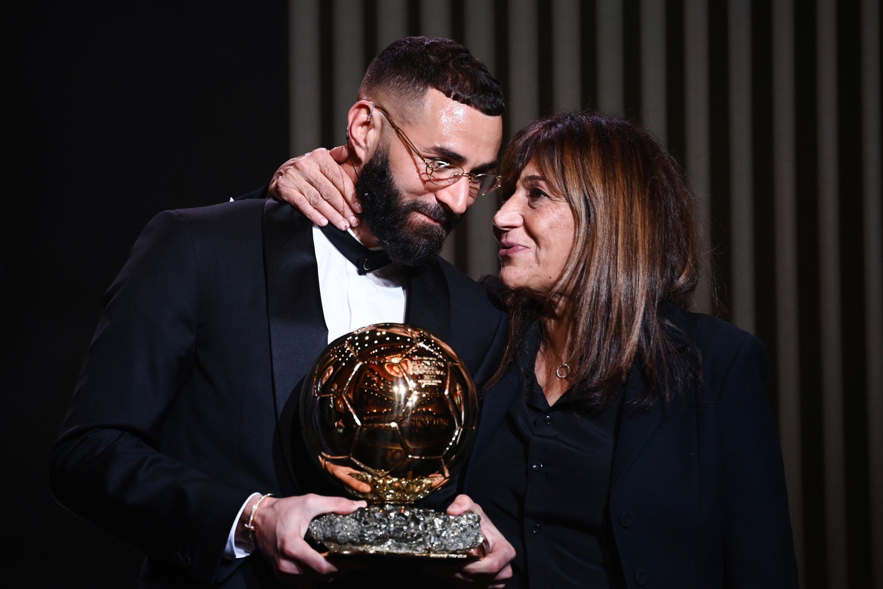 L'attaquant français du Real Madrid Karim Benzema (G) reçoit le Ballon d'Or aux côtés de sa mère Malika Benzema lors de la cérémonie de remise du Ballon d'Or France Football 2022 (AFP)