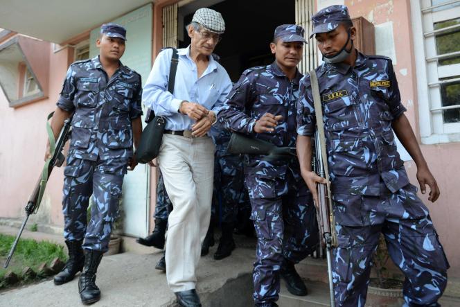 In this file photo, French serial killer Charles Sobhraj is escorted by Nepalese police to a vehicle after a court hearing.  In Bhaktapur, Nepal, on June 12, 2014. 