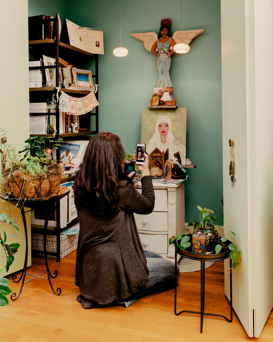 Susan Pannier-Cass, spiritual director and ordained minister, kneels in front of an altar at her home in Chicago on Dec. 11, 2020. (Evan Jenkins/The New York Times)