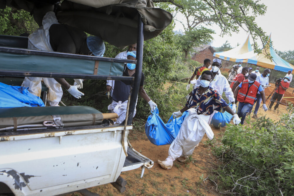 Police and local people carry exhumed bodies to a truck in the village of Shakahola, near Malindi, Kenya, on April 23, 2023.  (AP Photo)